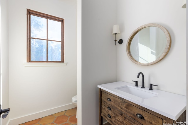 bathroom with tile patterned floors, baseboards, toilet, and vanity