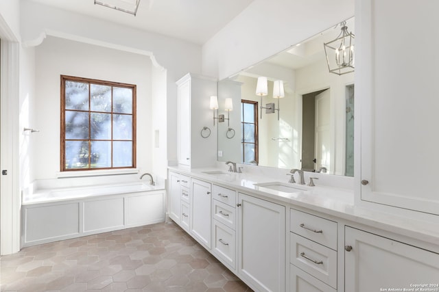 full bath featuring tile patterned floors, a garden tub, double vanity, and a sink