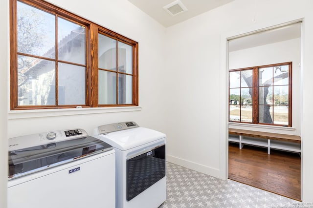 laundry area with independent washer and dryer, visible vents, baseboards, tile patterned floors, and laundry area