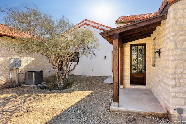 exterior space featuring stucco siding, central AC, and a tile roof