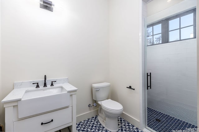 bathroom featuring tile patterned floors, toilet, a shower with door, and vanity