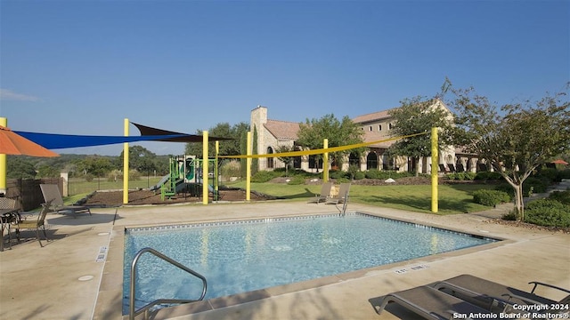 view of pool featuring a playground and a patio area