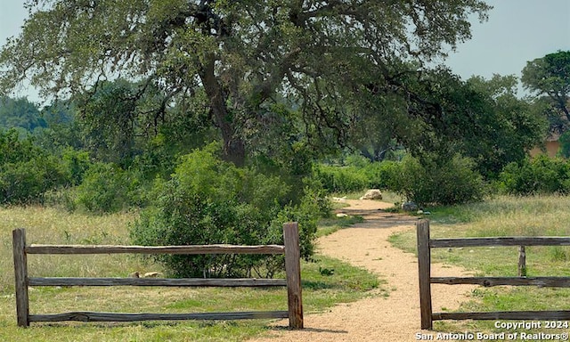 view of gate featuring fence and a rural view