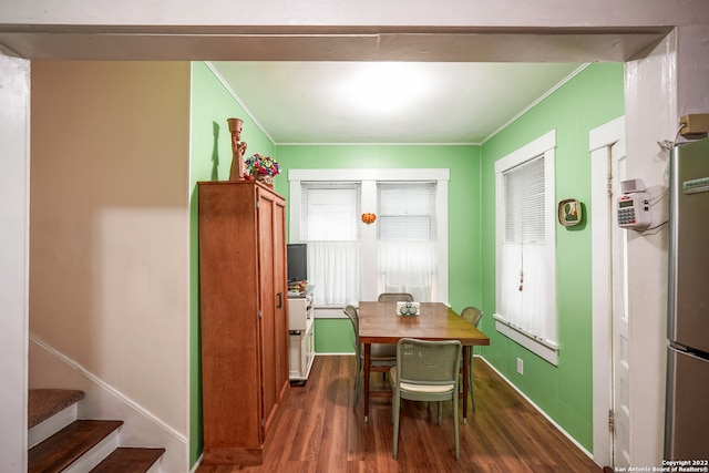 dining room featuring dark hardwood / wood-style floors and crown molding