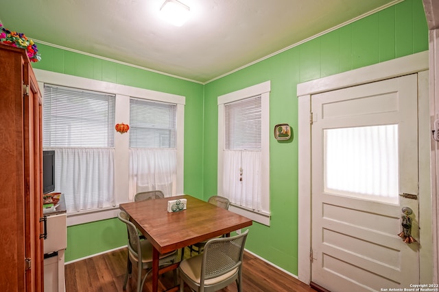 dining area with crown molding, dark hardwood / wood-style flooring, and a healthy amount of sunlight