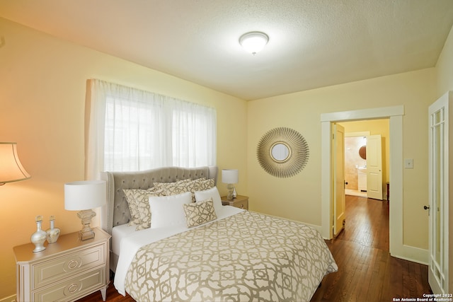 bedroom featuring a textured ceiling and dark wood-type flooring