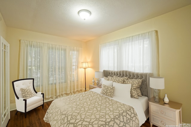 bedroom featuring a textured ceiling and dark wood-type flooring