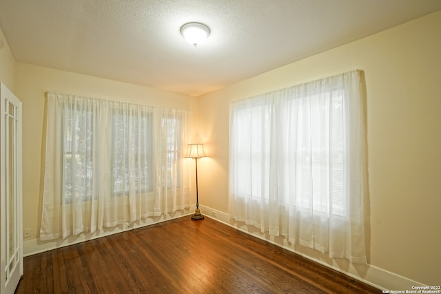 spare room featuring a textured ceiling and hardwood / wood-style floors