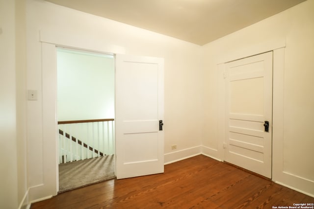 spare room featuring dark wood-type flooring