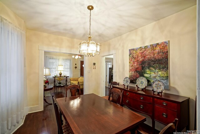 dining area featuring an inviting chandelier and dark hardwood / wood-style flooring