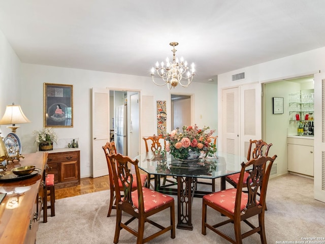 carpeted dining room featuring a chandelier