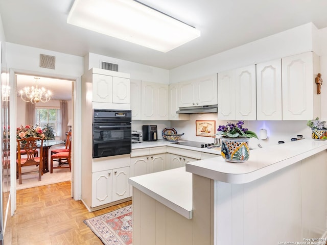 kitchen featuring white cabinets, pendant lighting, kitchen peninsula, black appliances, and an inviting chandelier