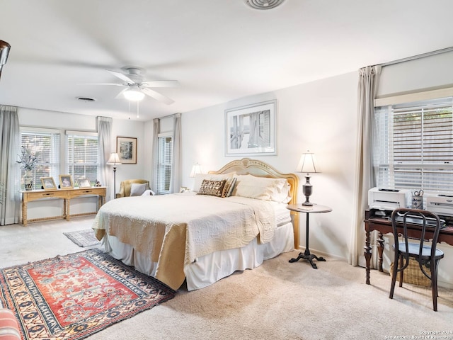 carpeted bedroom featuring ceiling fan and multiple windows