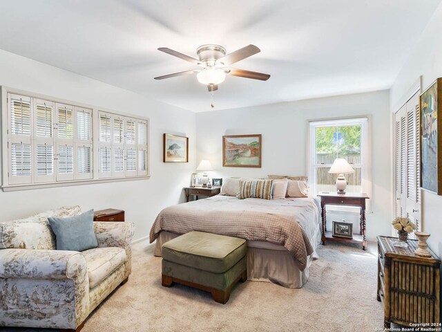 carpeted bedroom featuring ceiling fan and a closet