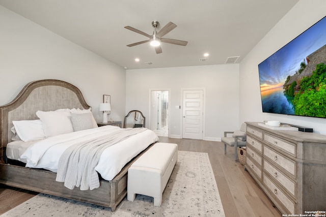 bedroom featuring ceiling fan, ensuite bathroom, and light hardwood / wood-style floors