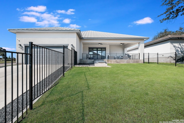 back of property with ceiling fan, a lawn, and a patio area