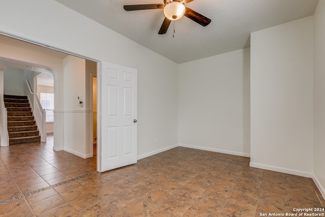 empty room featuring lofted ceiling and ceiling fan