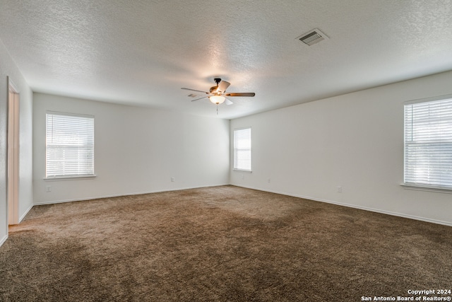 spare room with a textured ceiling and carpet