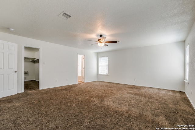 carpeted spare room featuring a textured ceiling and ceiling fan