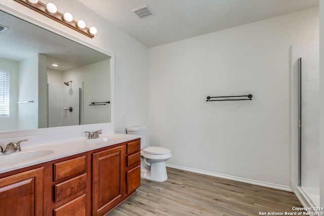 bathroom with vanity, walk in shower, a textured ceiling, hardwood / wood-style flooring, and toilet