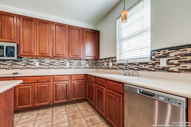 kitchen with pendant lighting, sink, decorative backsplash, stainless steel appliances, and light tile patterned floors