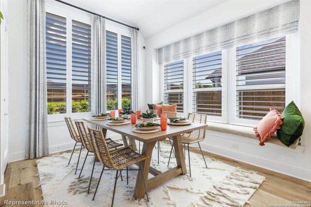 dining room with vaulted ceiling and light wood-type flooring