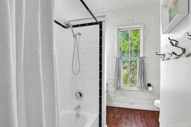 bathroom featuring tiled shower / bath combo, hardwood / wood-style floors, and toilet