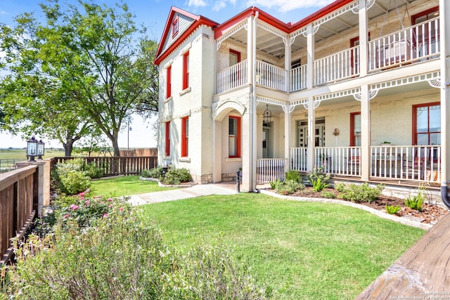 exterior space with a balcony and a front lawn