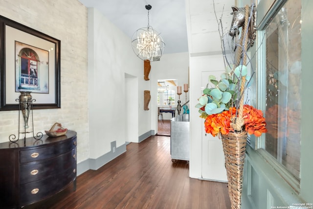 hallway with an inviting chandelier, a high ceiling, and dark wood-type flooring