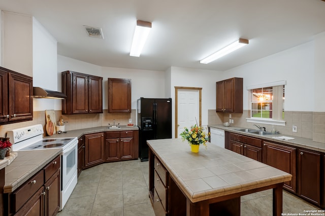 kitchen with tasteful backsplash, white appliances, sink, tile countertops, and a center island