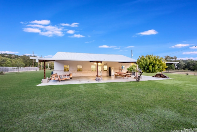 back of property with a yard and a patio