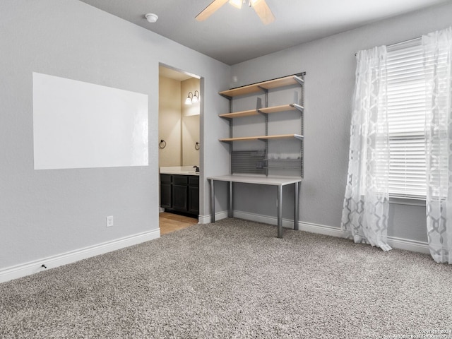 unfurnished office with ceiling fan and light colored carpet