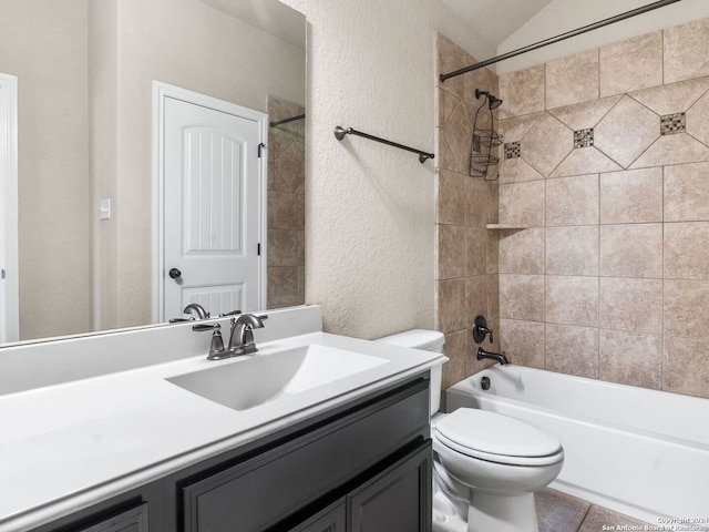 full bathroom featuring tiled shower / bath, vanity, and toilet