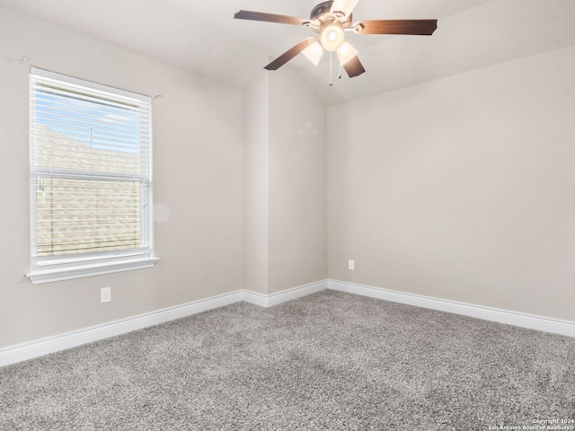 carpeted empty room with ceiling fan, lofted ceiling, and a healthy amount of sunlight