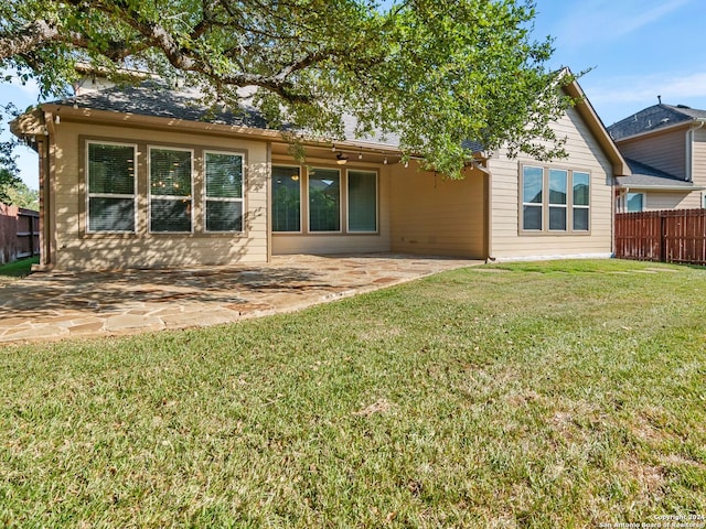 back of house with a lawn and a patio area