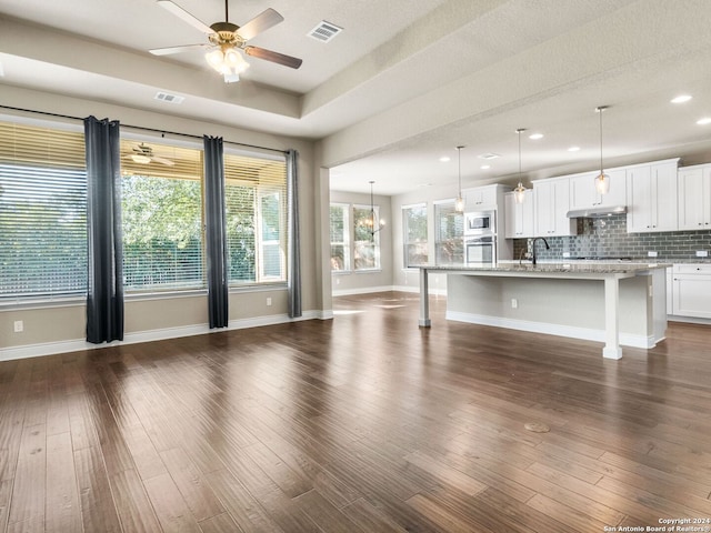 unfurnished living room with a textured ceiling, ceiling fan, sink, and dark hardwood / wood-style flooring