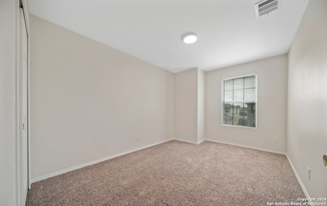 unfurnished room featuring light colored carpet