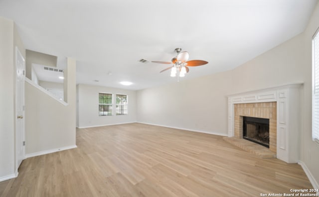 unfurnished living room featuring ceiling fan, light hardwood / wood-style flooring, and a brick fireplace