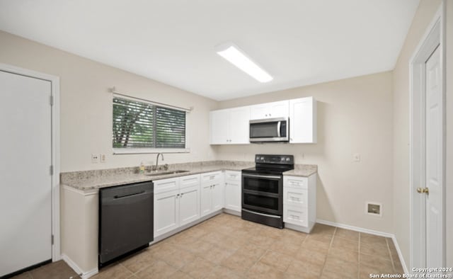 kitchen featuring sink, light stone countertops, white cabinetry, and black appliances