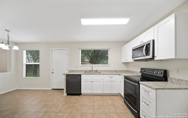 kitchen with black appliances, a wealth of natural light, sink, and white cabinets