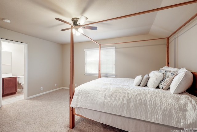 carpeted bedroom featuring ceiling fan, ensuite bath, and vaulted ceiling