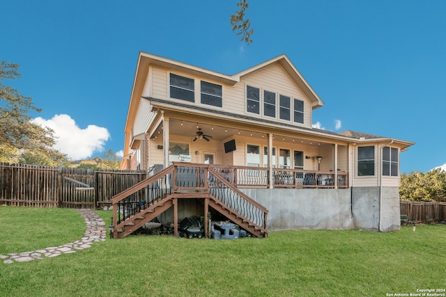 back of property with ceiling fan and a yard