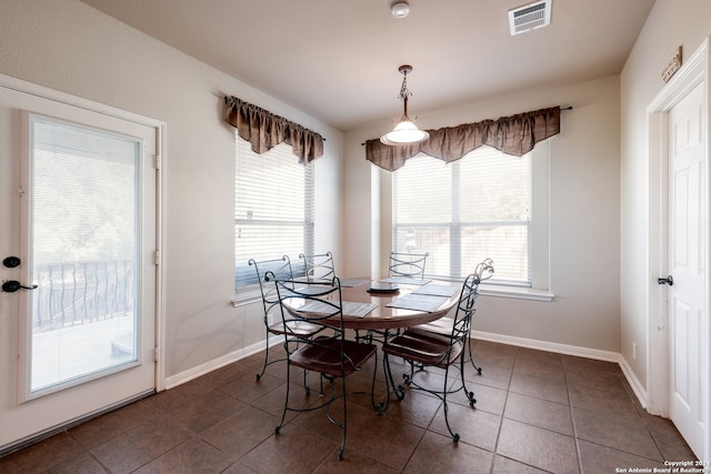 dining space with dark tile patterned floors