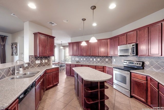 kitchen with a center island, appliances with stainless steel finishes, hanging light fixtures, and sink