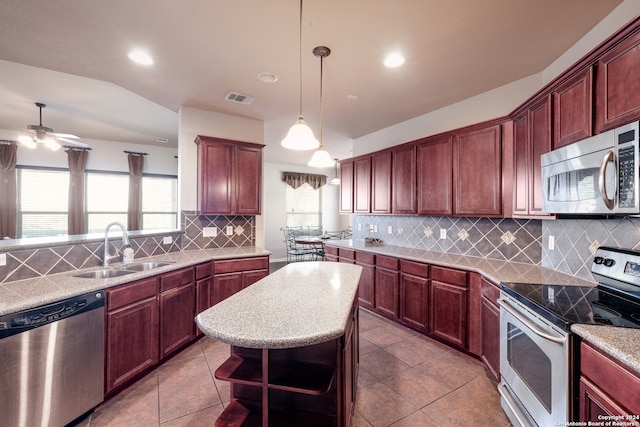 kitchen with pendant lighting, sink, decorative backsplash, stainless steel appliances, and ceiling fan