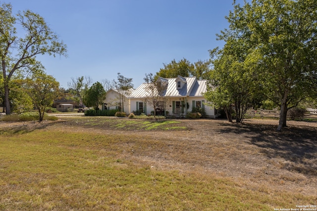 cape cod home with a front lawn