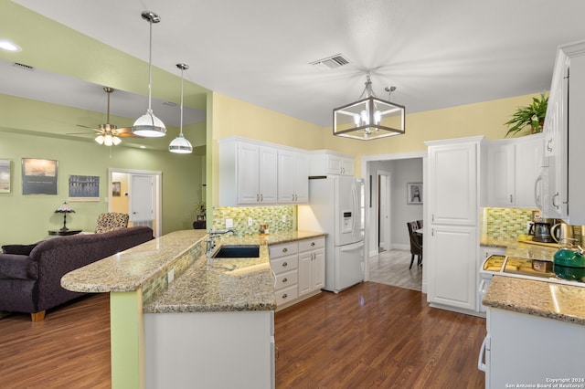 kitchen featuring tasteful backsplash, kitchen peninsula, white appliances, and white cabinetry