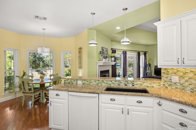 kitchen with white dishwasher, white cabinetry, decorative light fixtures, and sink