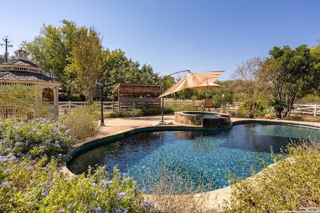 view of swimming pool featuring a gazebo, an in ground hot tub, and a patio area