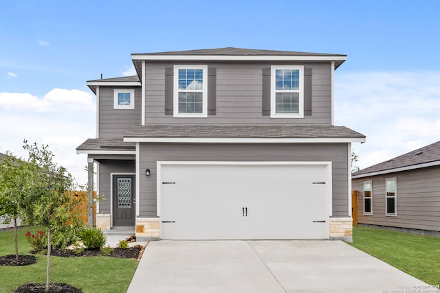 view of property featuring a garage and a front yard